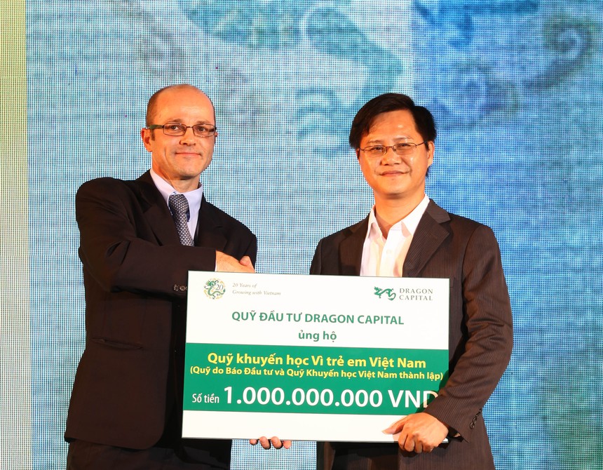 Ông Nguyễn Hồng (phải), Phó Tổng biên tập Báo Kl99ok phiên bản mới đón nhận tiền tượng trưng cho quỹ học bổng của báo từ đại diện của Dragon Capital - ảnh: Lê Toàn