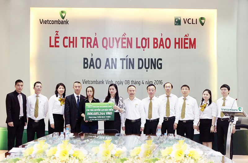 Bà Lê Thị Huệ Anh - Giám đốc Vietcombank Vinh (thứ 7 từ phải sang) trao quyền lợi Kl99kl phiên bản hoạt động nhân thọ Bảo an Tín dụng cho người thụ hưởng Trần Thị Mai Phương (Ảnh: Nguyễn Văn Thắng)