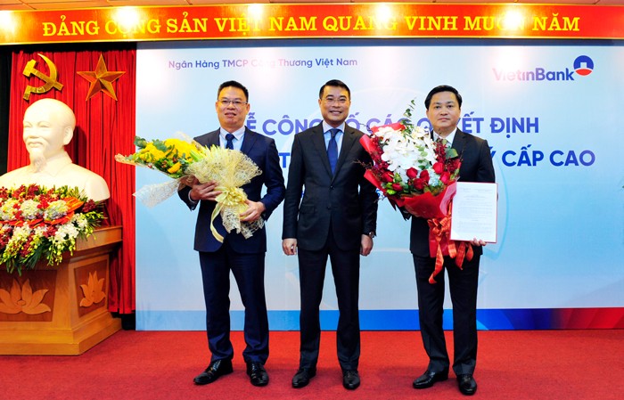 Thống đốc NHNN Lê Minh Hưng trao Quyết định đại diện phần vốn 99Kl99 trực tiếp đá gà tại VietinBank cho ông Lê Đức Thọ - Chủ tịch HĐQT và tặng hoa chúc mừng ông Lê Đức Thọ - Chủ tịch HĐQT (phải) và ông Trần Minh Bình - Quyền Tổng Giám đốc (trái).