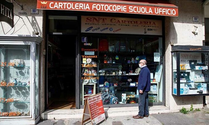 Người dân đứng trước một cửa hàng ở thành phố Catania, Italy hôm nay, sau khi Kl993 ưu đãi thưởng hấp dẫn cho phép một số nơi mở cửa lại. Ảnh: Reuters.