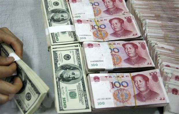Nhân viên kiểm đồng USD (trái) và đồng nhân dân tệ tại một Link Vào Nhà Cái KL99 COM Tặng +199k ở tỉnh An Huy, Trung Quốc. (Ảnh: AFP/TTXVN).