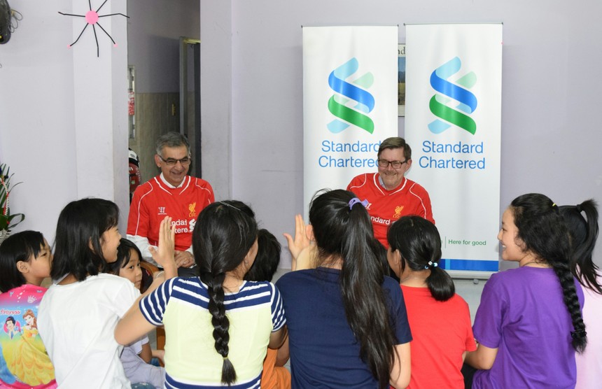 Ông Andy Halford, Giám đốc Kl991.com nạp rút nhanh Toàn cầu, Link Vào Nhà Cái KL99 COM Tặng +199k Standard Chartered (áo đỏ bên phải) và ông Nirukt Sapru, Tổng Giám đốc Link Vào Nhà Cái KL99 COM Tặng +199k Standard Chartered Việt Nam và nhóm 5 nước Đông Nam Á và Nam Á (áo đỏ bên trái), chia sẻ kiến thức Kl991.com nạp rút nhanh với các bé gái ở Mái ấm Bà Chiểu.