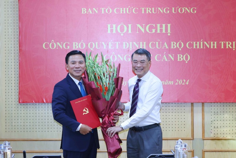 Trưởng ban Tổ chức Trung ương Lê Minh Hưng trao quyết định của Bộ Kl991.com tải ứng dụng, tặng hoa chúc mừng ông Đỗ Trọng Hưng. Ảnh: TTXVN