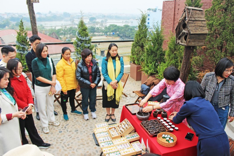 Đại biểu trải nghiệm tour “Đánh thức” tại xã Vân Đình, nghe giới thiệu về Thăng Long Chè Việt. Ảnh: TITC