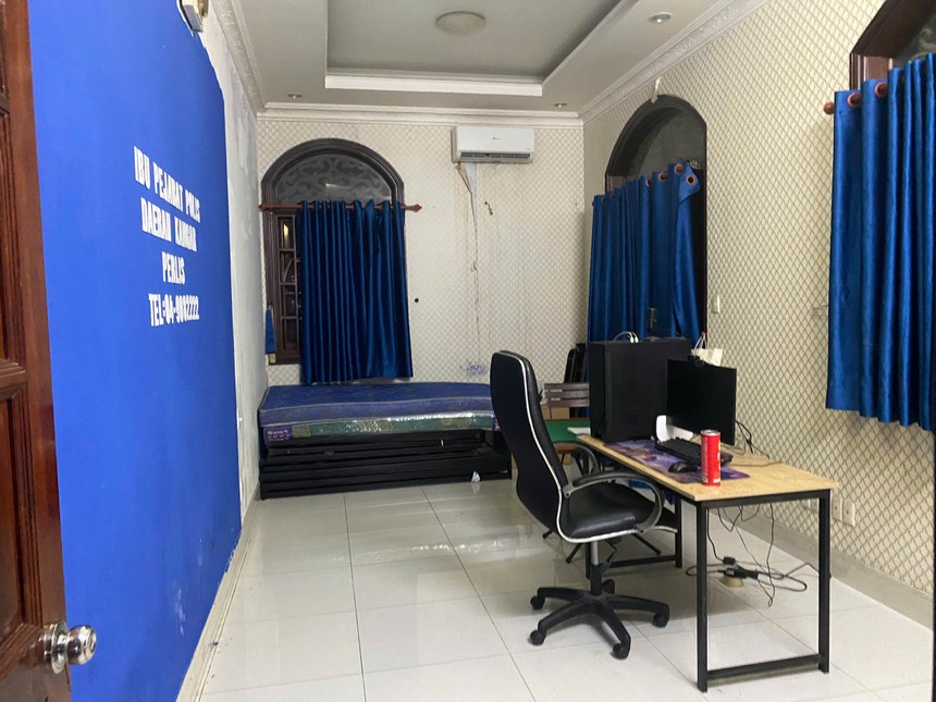 Một căn phòng nơi các đối tượng nước ngoài trú ngụ đã 'đầy đủ" phông bạt mô phỏng cơ quan chức năng nước ngoài cùng máy móc nghi vấn phục vụ lừa đảo online